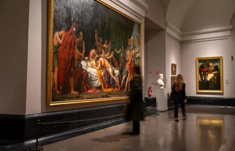 Salle d’exposition du musée du Prado à Madrid avec de grandes peintures et des visiteurs observant les œuvres.