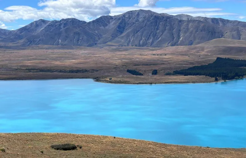 Lac Tekapo en Nouvelle-Zélande avec ses eaux turquoise et montagnes en arrière-plan