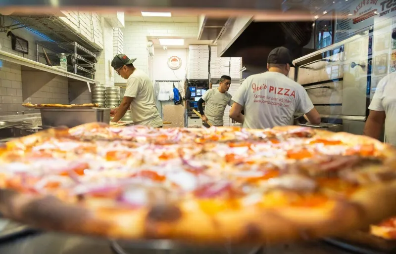 Chefs préparant une pizza new-yorkaise chez Joe’s Pizza à New York