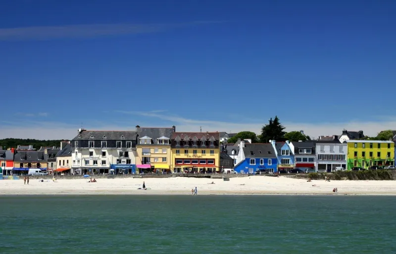 Plage de Morgat sur la presqu’île de Crozon avec sable fin, mer calme et maisons colorées en bord de plage