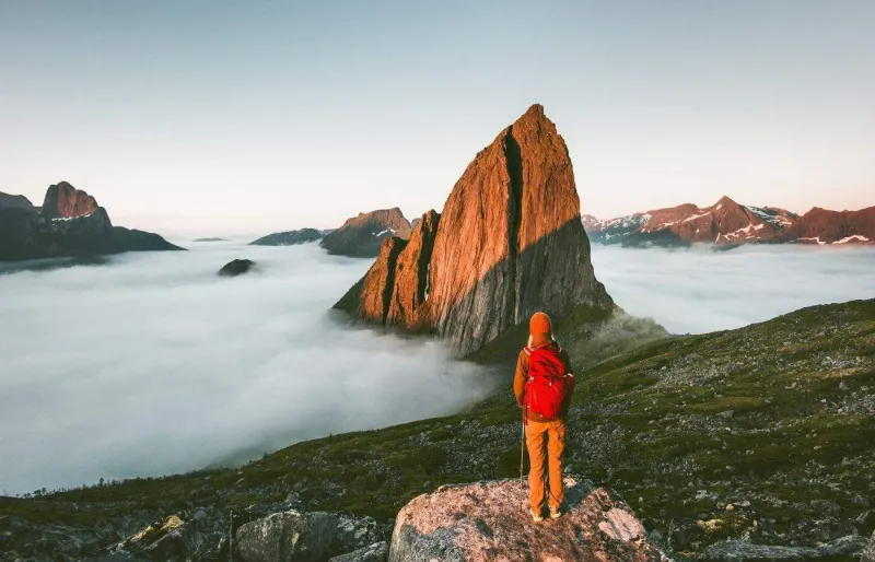 Randonneuse face à la montagne Segla au coucher du soleil sur l’île de Senja en Norvège