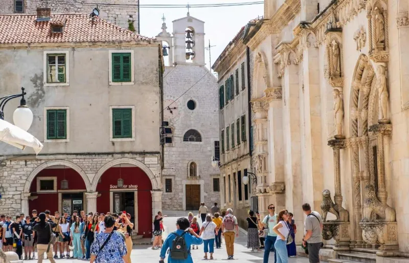 Place animée devant l’église Sainte-Barbara dans la vieille ville de Šibenik en Croatie