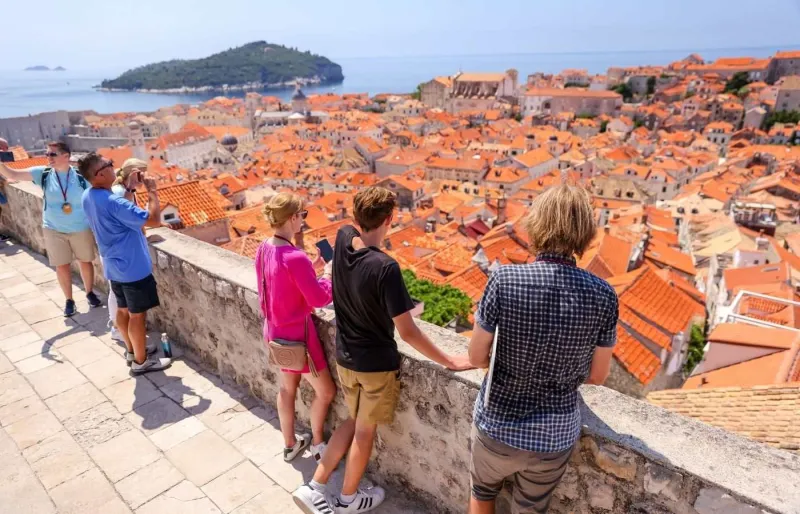 Guide touristique montrant la vieille ville depuis les remparts de Dubrovnik à des visiteurs