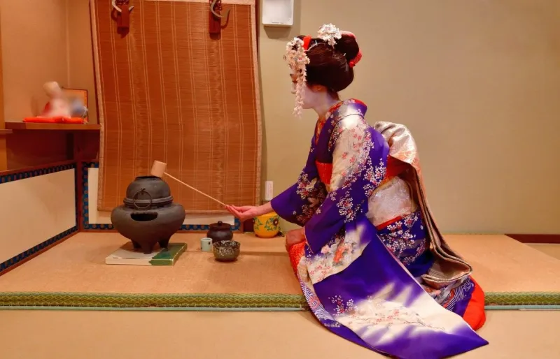 Maiko japonaise pratiquant la cérémonie du thé à Kyoto dans une maison de thé traditionnelle
