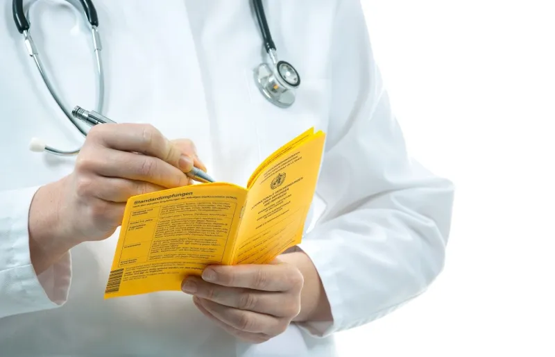 Médecin remplissant un certificat international de vaccination pour voyage