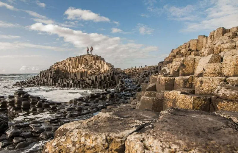 Randonneurs sur les colonnes de basalte de la Chaussée des Géants en Irlande du Nord
