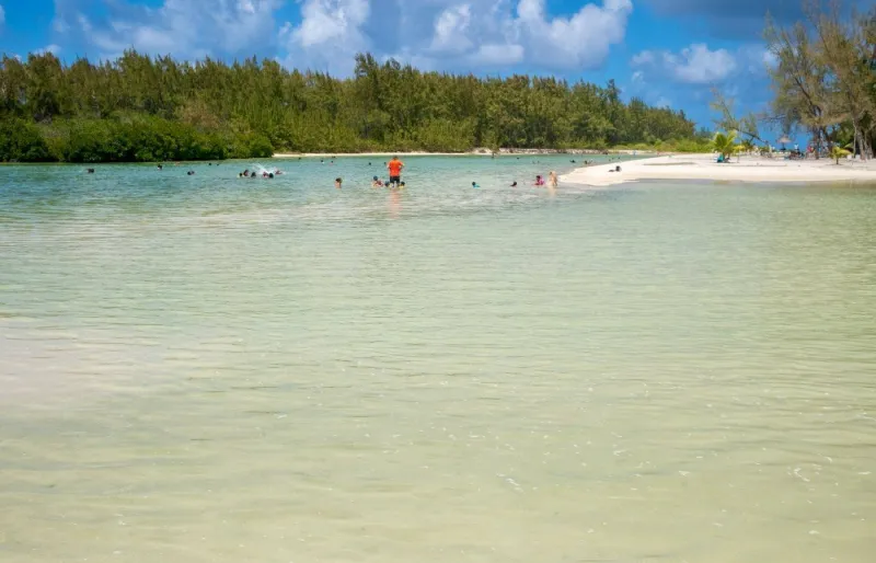 Lagon turquoise de l’île aux Cerfs à l’île Maurice avec baigneurs dans une eau peu profonde