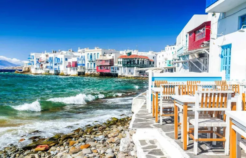 Maisons colorées de la Petite Venise à Mykonos avec terrasse en bord de mer et vue sur les vagues