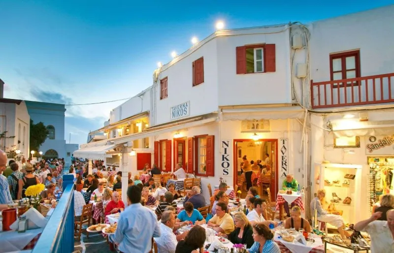 Clients dînant en terrasse dans une taverne à Mykonos le soir dans le centre de Hora