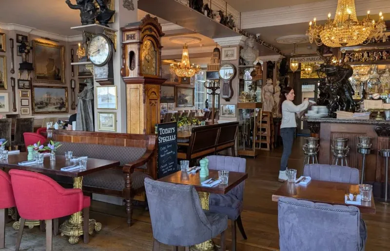 Intérieur élégant du pub Trafalgar Tavern à Londres avec lustres, mobilier victorien et décoration raffinée