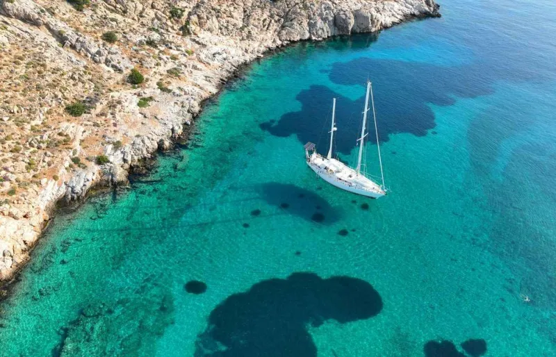 Voilier de luxe au mouillage dans la baie d’Ornos à Mykonos avec vue aérienne sur la côte