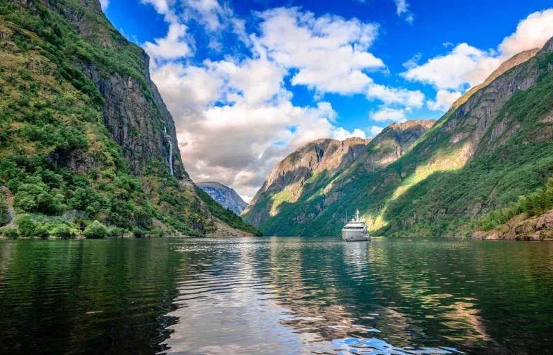 Bateau de croisière sur l’Aurlandsfjord en Norvège entouré de montagnes escarpées