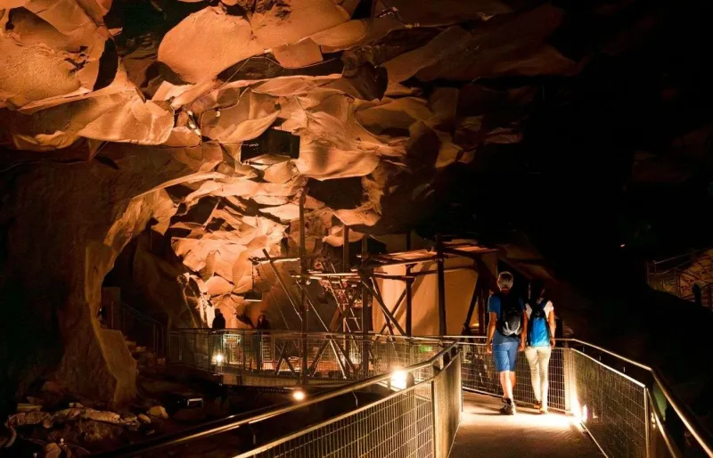 Visiteurs dans la Grotte de la Pierre de Volvic au cœur d’une ancienne coulée de lave