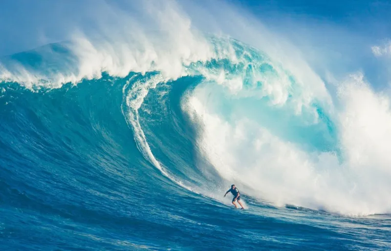 Surfeur affrontant une vague géante à Jaws à Hawaii, célèbre spot de big wave surfing sur l’île de Maui