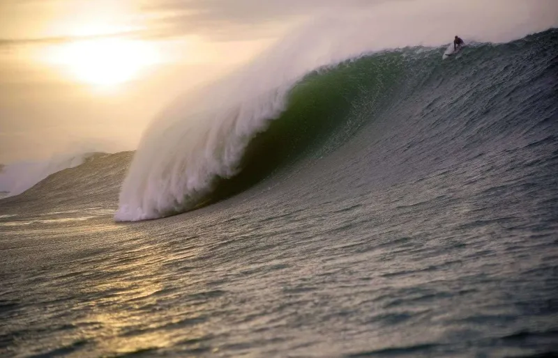 Surfeur sur une vague géante à Mullaghmore Head en Irlande, célèbre spot de surf extrême de l’Atlantique