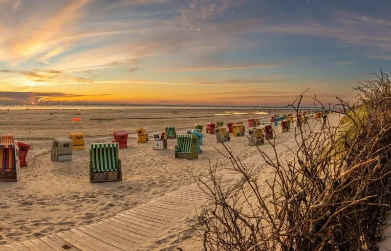 Plage de Langeoog en mer du Nord avec Strandkörbe au coucher du soleil dans les îles de la Frise orientale