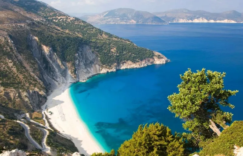 Vue panoramique de la plage de Myrtos à Céphalonie avec falaises escarpées, galets blancs et mer turquoise
