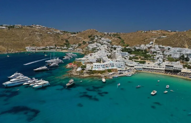 La plage de Platys Gialos à Mykonos avec ses eaux turquoise et ses nombreux bateaux au large