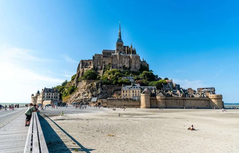Vue de l’abbaye du Mont-Saint-Michel dominant la baie en Normandie à marée basse, l’un des monuments les plus emblématiques de France