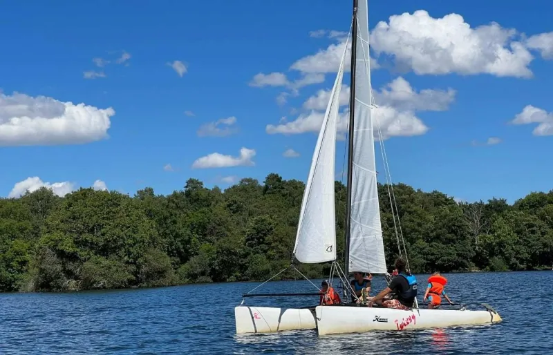 Catamaran naviguant sur le lac d'Aydat, le plus grand lac naturel d'Auvergne, dans le Puy-de-Dôme.