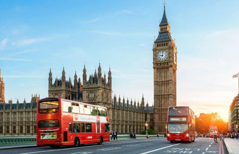 Big Ben et le palais de Westminster à Londres vus depuis Westminster Bridge avec des bus rouges impériaux