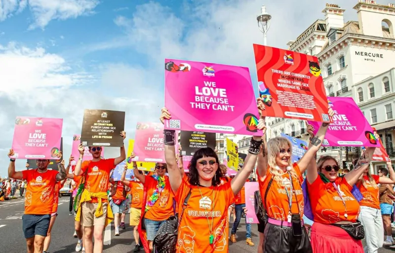 Participants à un défilé LGBTQ+ dans les rues de Brighton, ville reconnue pour l'importance de sa communauté queer au Royaume-Uni.