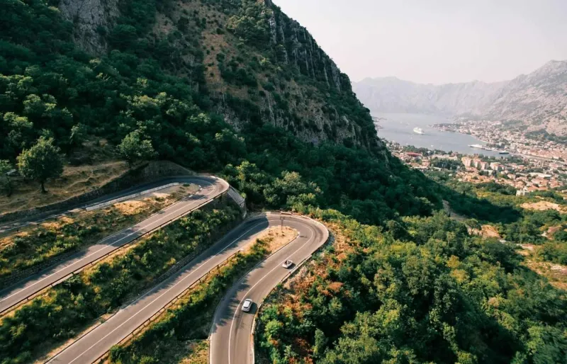 Voitures circulant sur une route de montagne au-dessus de la baie de Kotor au Monténégro