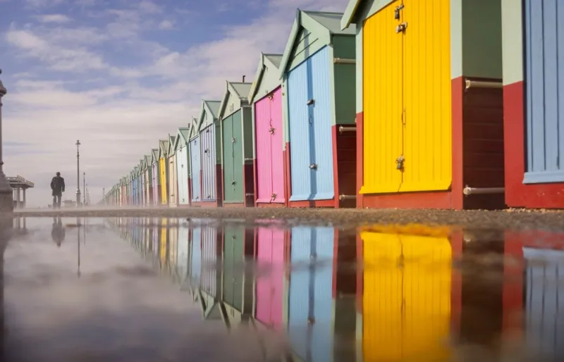 Cabanes colorées du front de mer de Brighton, ville réputée pour son patrimoine culturel et son histoire LGBTQ+ au Royaume-Uni.