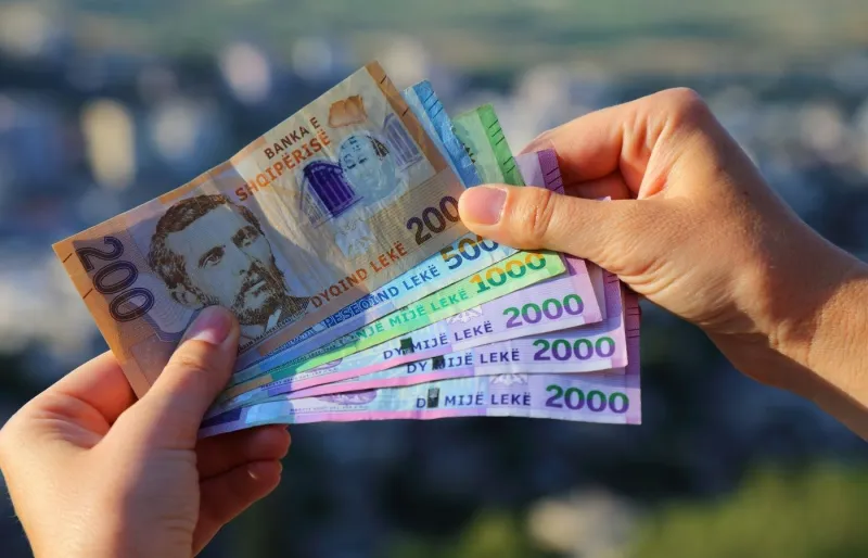 illets de lek albanais dans les mains d’un voyageur, la monnaie utilisée pour les paiements en espèces en Albanie.