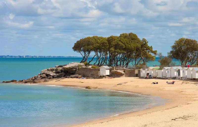 La plage des Dames à Noirmoutier en Vendée avec ses cabines de bain blanches et ses eaux calmes