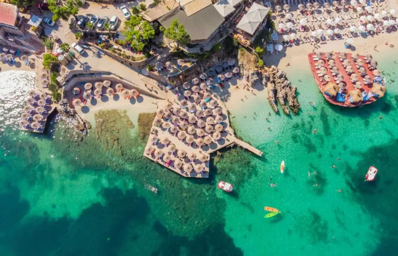 Vue aérienne de la plage de Ksamil en Albanie bondée pendant la haute saison estivale sur la Riviera albanaise.