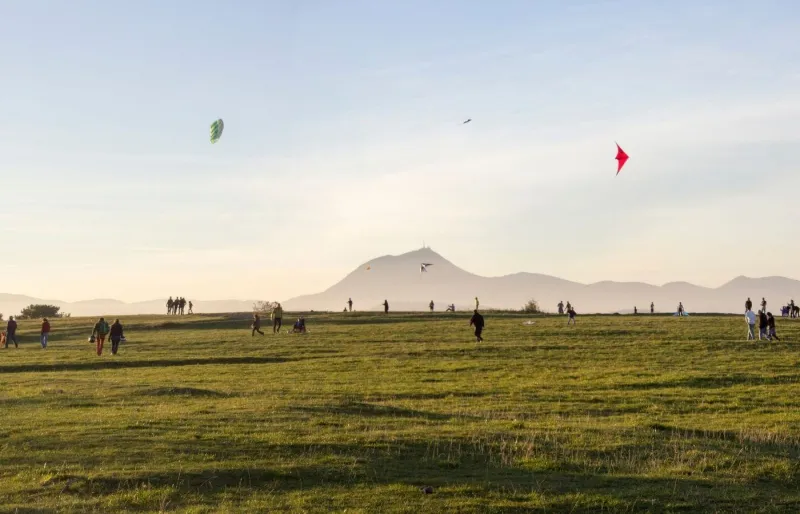 Promeneurs sur le plateau de Gergovie avec le puy de Dôme en arrière-plan