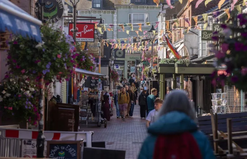 Rue commerçante animée de Brighton décorée de drapeaux arc-en-ciel, au cœur de l'une des principales destinations LGBTQ+ du Royaume-Uni.