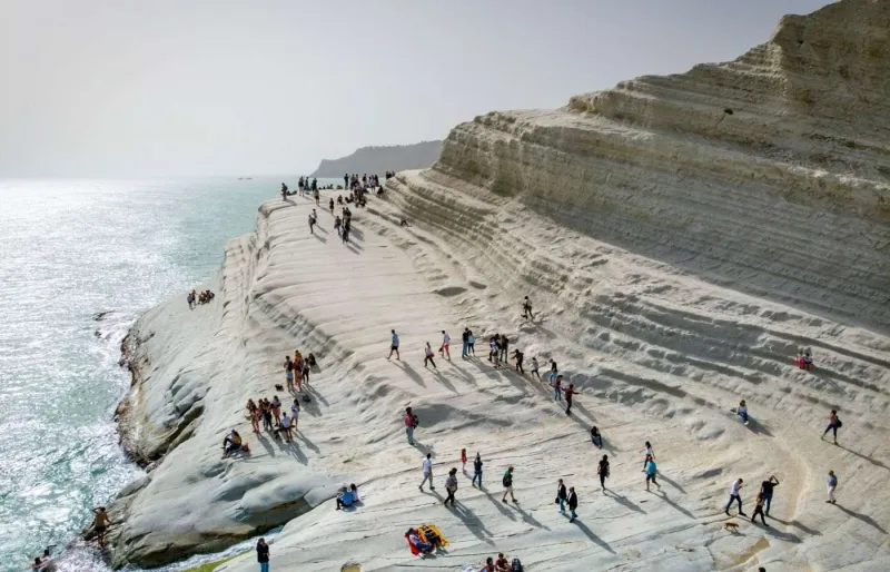 Des visiteurs se promènent sur les falaises blanches de la Scala dei Turchi près d’Agrigente en Sicile