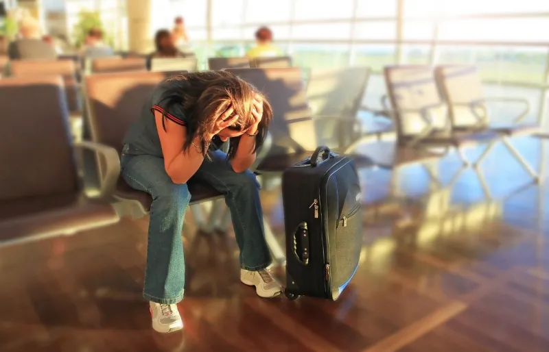 Passagère attendant dans un aéroport après un vol retardé ou annulé.