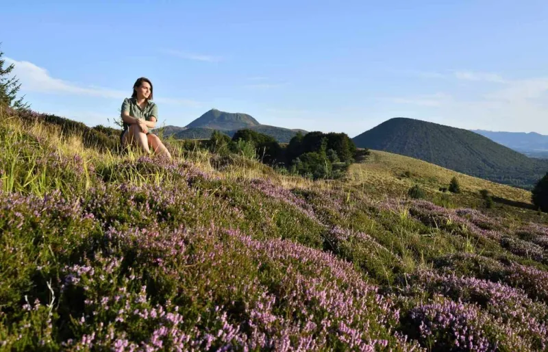 Randonneuse face aux volcans de la chaîne des Puys dans le Puy-de-Dôme, au cœur des paysages naturels d'Auvergne.