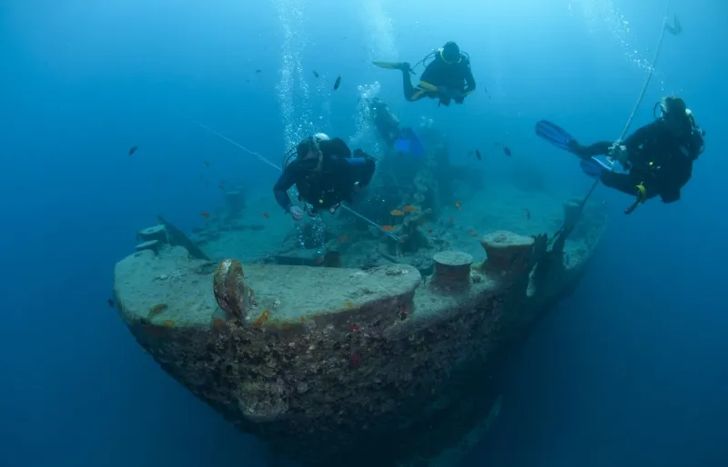 Des plongeurs explorent l'étrave du SS Thistlegorm, célèbre épave de plongée dans le détroit de Gubal, en mer Rouge.