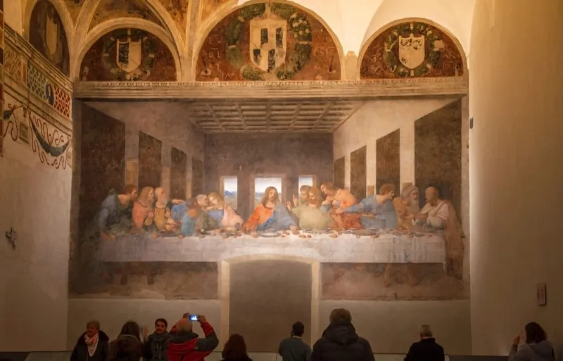 Des visiteurs admirent La Cène de Léonard de Vinci au Cenacolo Vinciano de Milan, dans l'église Santa Maria delle Grazie.