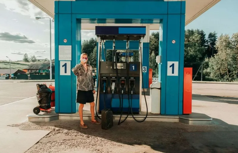 Voyageur en auto-stop dans une station-service, l’un des meilleurs endroits pour trouver un conducteur