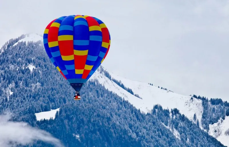 Montgolfière au-dessus des Alpes suisses enneigées à Château-d'Œx en Suisse