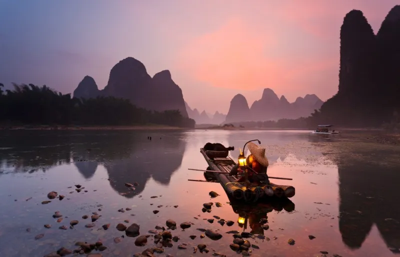 Pêcheur au cormoran sur la rivière Li près de Xingping, avec les pics karstiques de Yangshuo en Chine