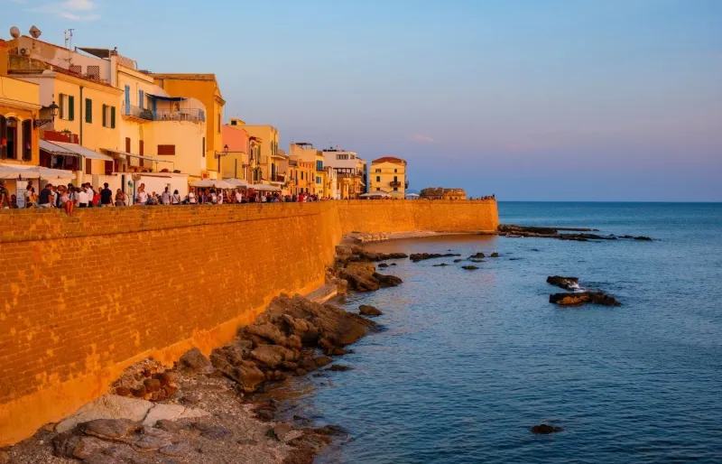 Remparts d'Alghero au coucher du soleil avec vue sur la baie et la mer en Sardaigne