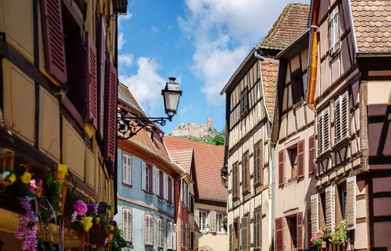 Maisons à colombages dans le centre historique de Ribeauvillé avec les ruines d'un château médiéval