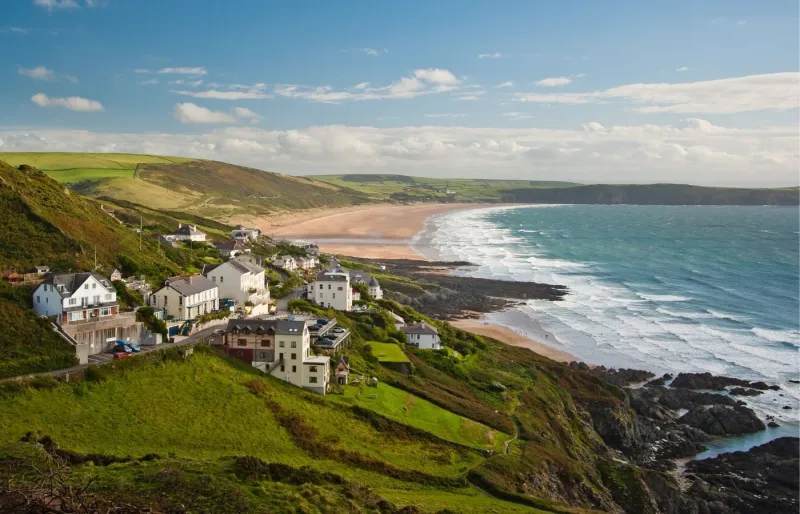 Vue panoramique de la côte du Devon et des Cornouailles avec plage, falaises et village en bord de mer lors d'un road trip en Angleterre