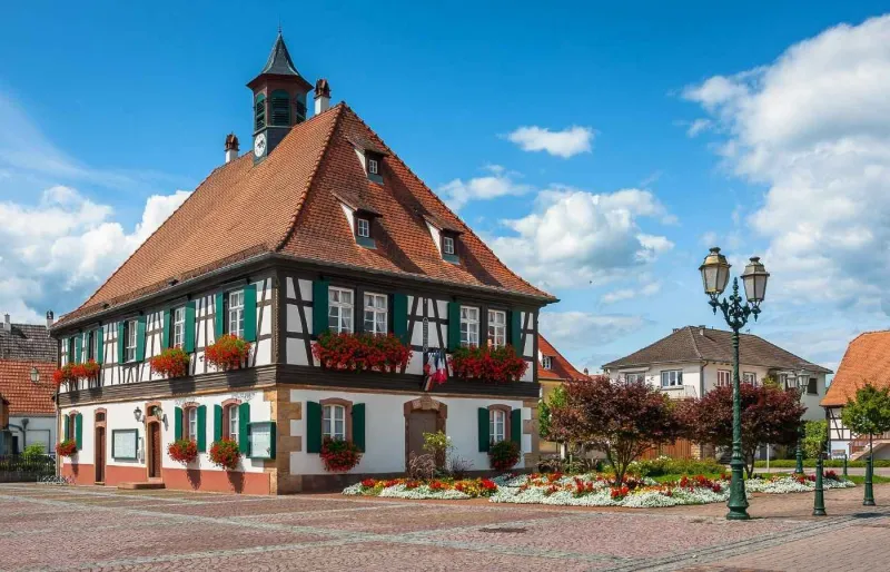 airie à colombages fleurie sur la place du village de Seebach en Alsace