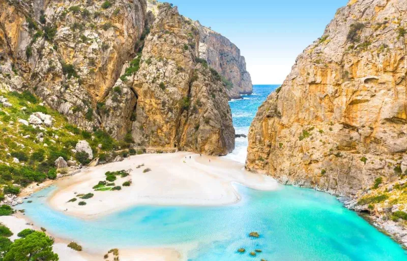 Plage de Torrent de Pareis à Sa Calobra, encadrée par les falaises de la Serra de Tramuntana