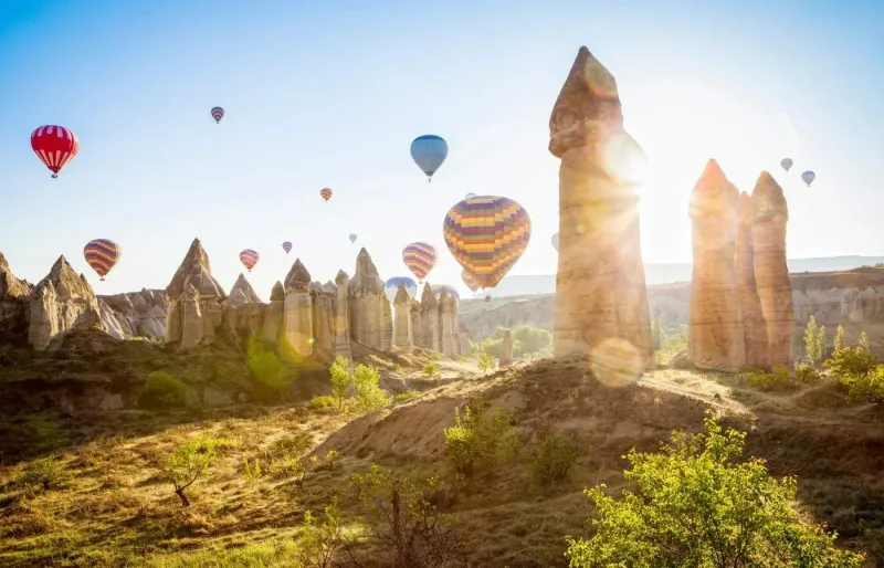 Montgolfières au-dessus des cheminées de fées en Cappadoce au lever du soleil