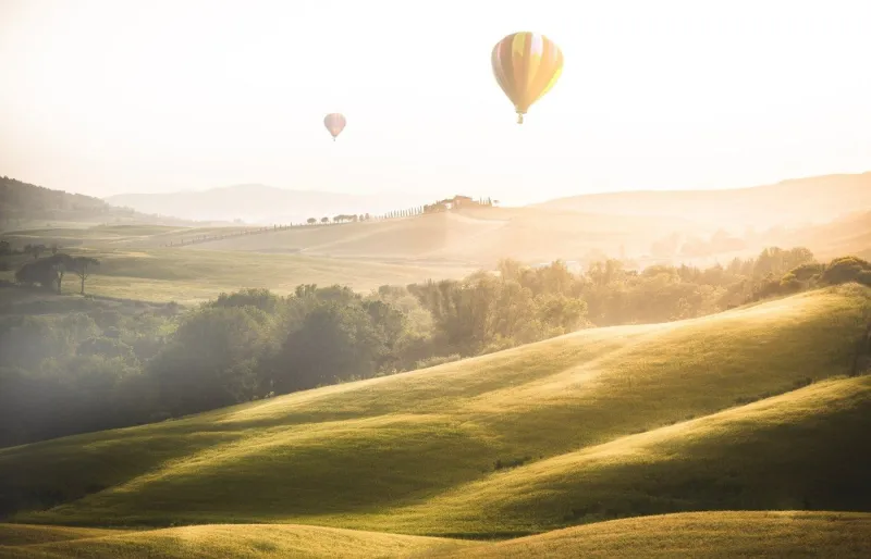 Montgolfières au lever du soleil au-dessus des collines de Toscane en Italie
