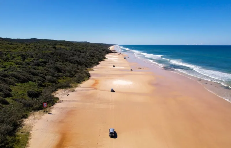 Véhicules 4x4 circulant sur 75-Mile Beach à K'gari, ancienne Fraser Island, dans le Queensland en Australie