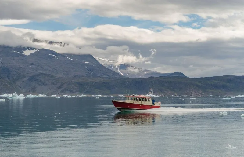 Bateau naviguant entre les icebergs dans le sud du Groenland